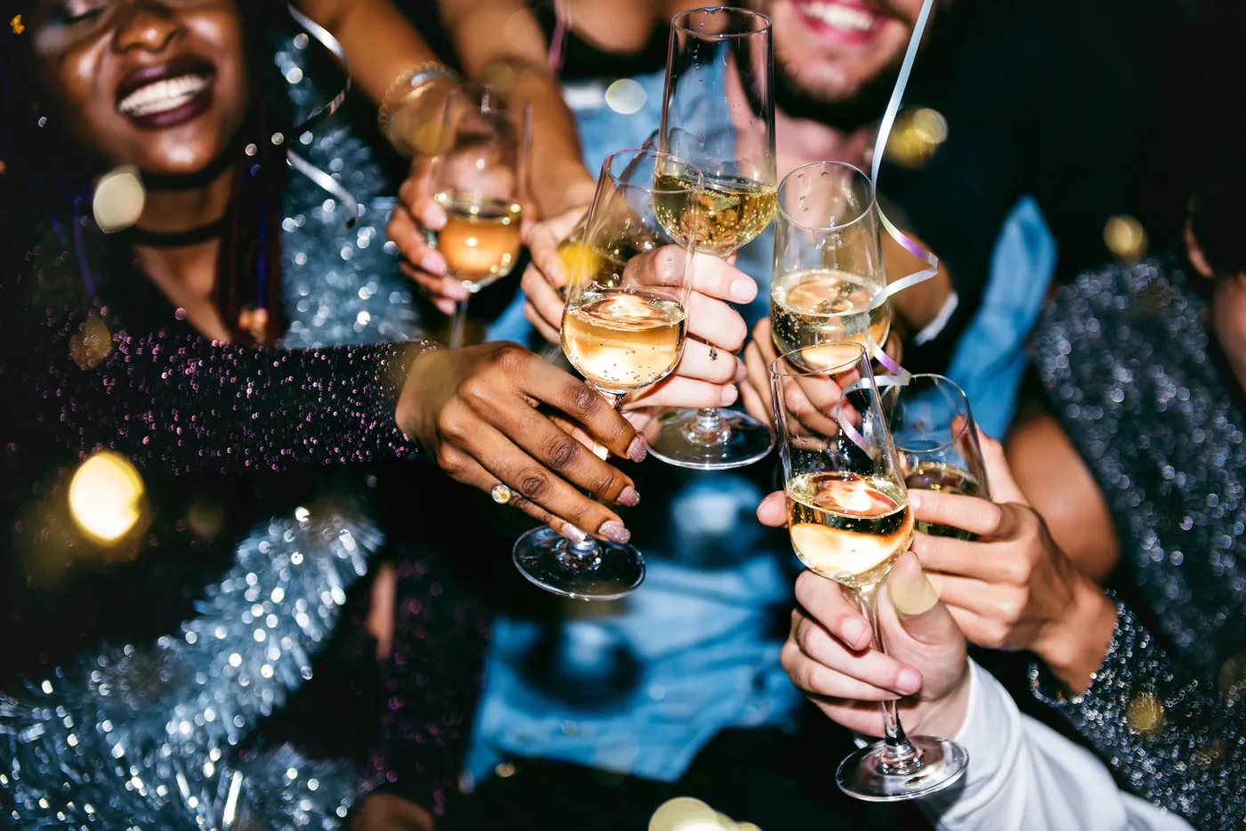 Freunde feiern ausgelassen und stoßen mit Sekt an