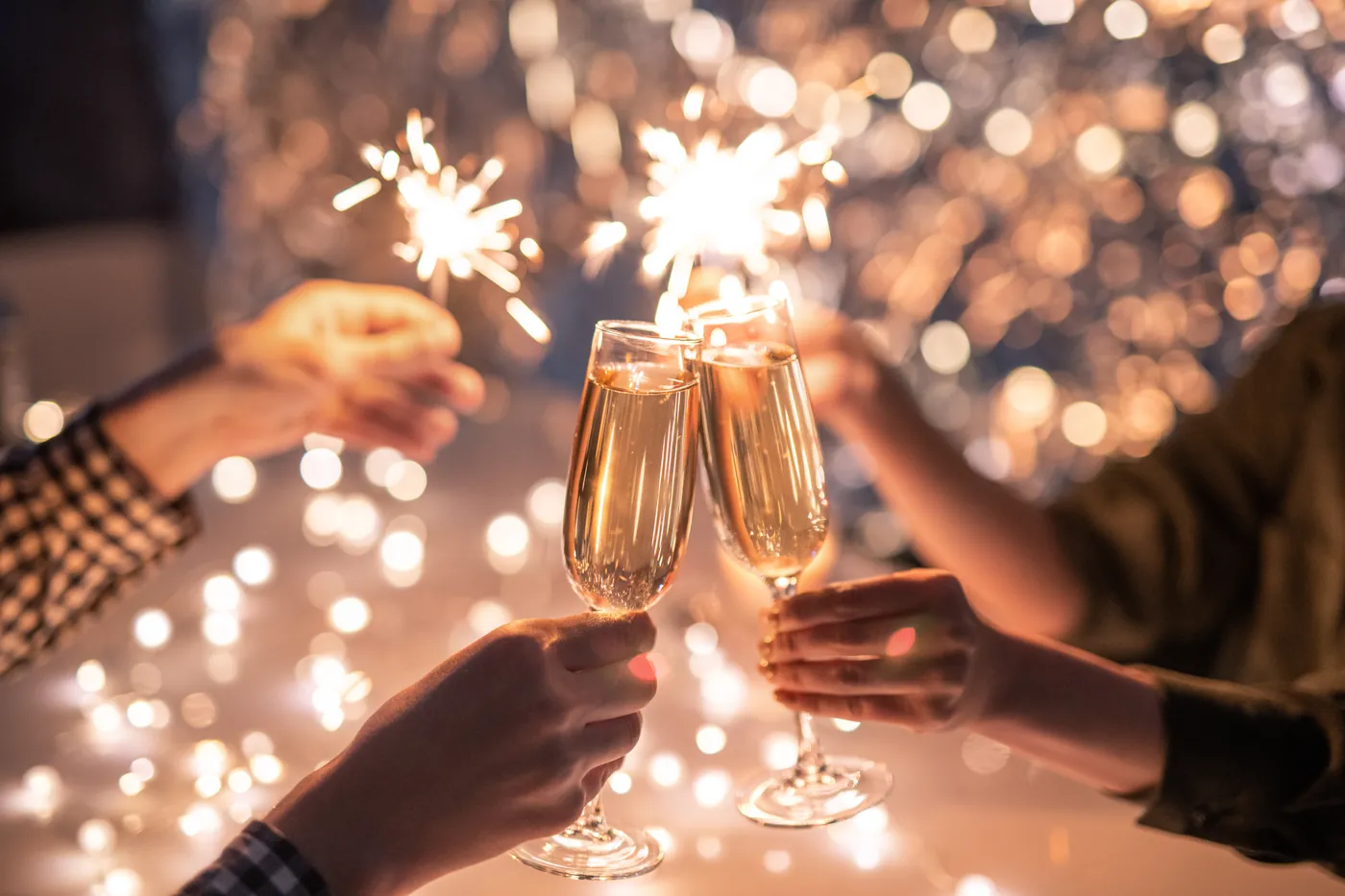Anstoßen mit Sekt und brennenden Wunderkerzen